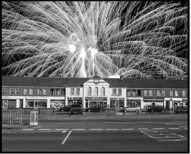 A magnificent fireworks display lights up the sky behind the Elms Parade shops.